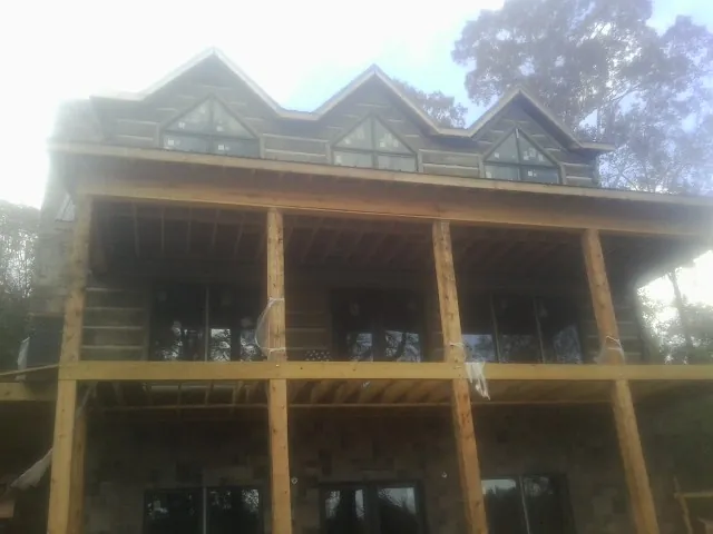 Dormers and porch framing on a large log home under construction — Roof Coating work by our crew in Duncan